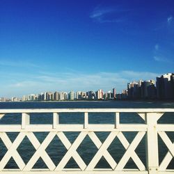 River in front of cityscape against blue sky