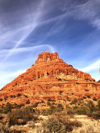 Rock formations on landscape against cloudy sky