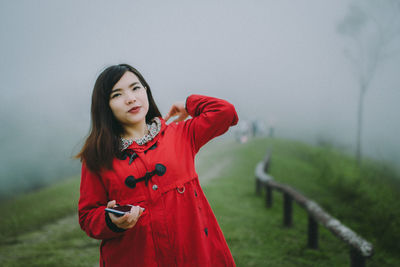 Beautiful young woman standing on field