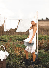 Woman hanging up laundry outdoor in a sunny day.