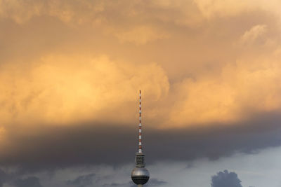 High section of fernsehturm tower against cloudy sky during sunset