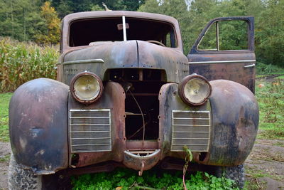 Abandoned vintage car on field
