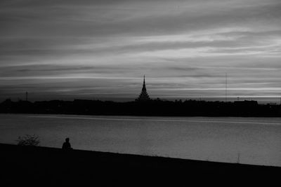 Silhouette of church against cloudy sky