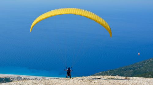 People paragliding against sea