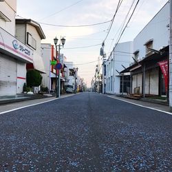 Empty road along buildings