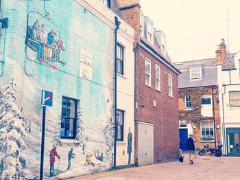 People walking on street amidst buildings in city