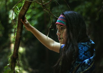 Side view of woman by tree