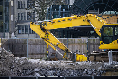 Yellow construction site by buildings in city