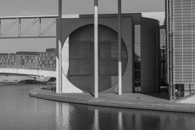 Arch bridge over river against buildings in city