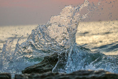 Close-up of sea waves splashing on rock