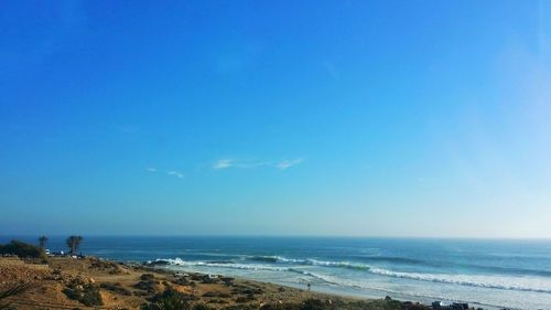 Scenic view of beach against clear blue sky