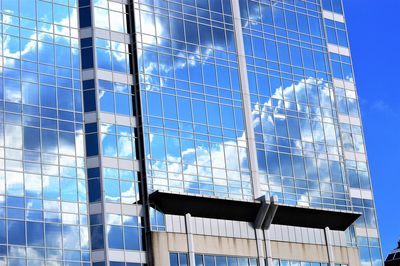 Low angle view of glass building against sky