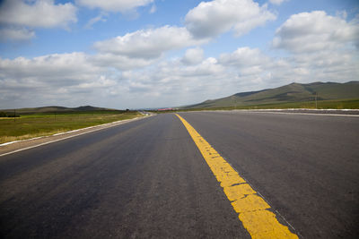 Empty road along countryside landscape