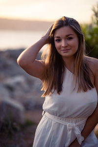 Portrait of young woman standing at beach