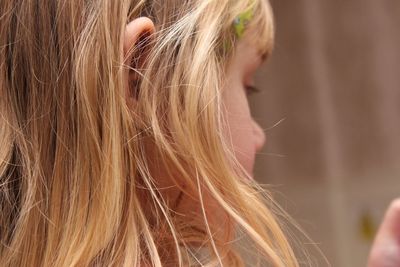 Close-up of girl with blond hair at home