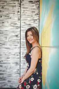 Portrait of woman standing against wall