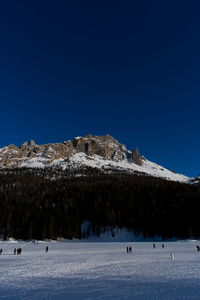 Scenic view of snowcapped mountains against clear blue sky