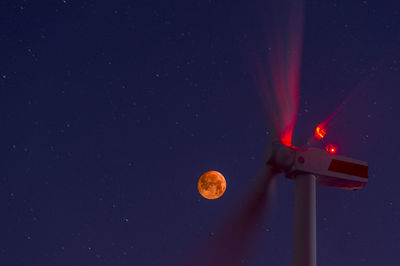 Low angle view of illuminated light against sky at night