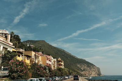 Buildings by sea against sky