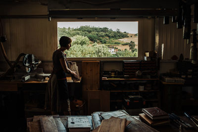 Woman working in a workshop with rural view