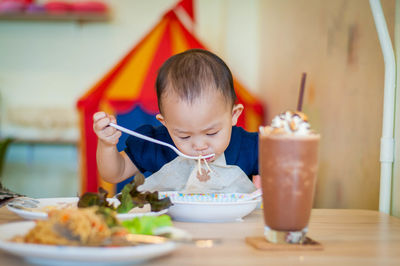 Boy eating food on table