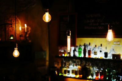 Illuminated light bulbs hanging at night