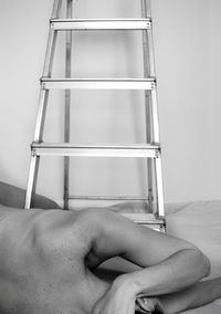 Midsection of man holding woman against wall at home