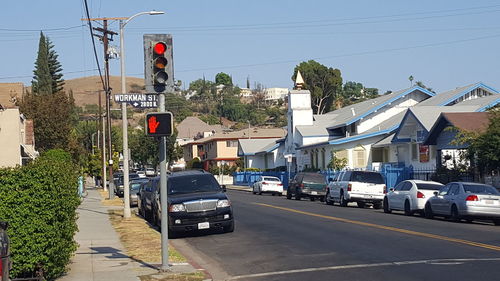 Cars on road by city against clear sky