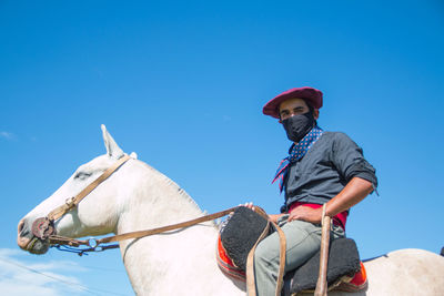 Man riding white horse 