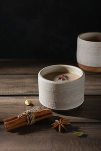 Ceramic cup of masala tea with spice on a wooden table