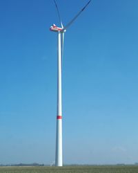 Low angle view of windmill against clear blue sky