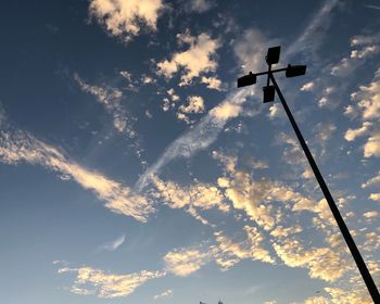 Low angle view of silhouette street lights against sky