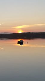 Silhouette boat in sea against sky during sunset