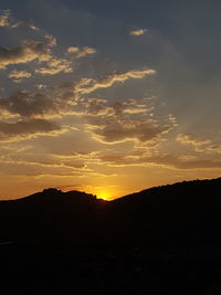 Scenic view of silhouette mountains against sky during sunset