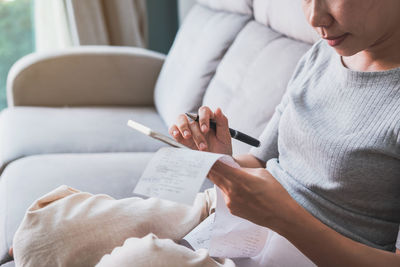 Midsection of woman reading book