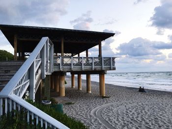 Pier on sea against cloudy sky