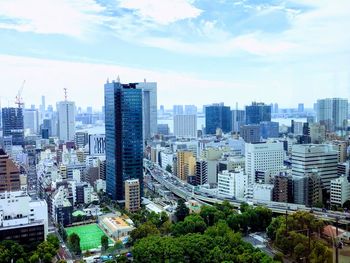 Aerial view of buildings in city against sky