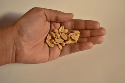 Close-up of hand holding food against white background