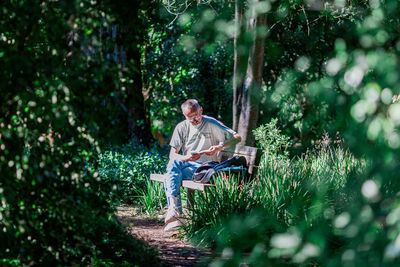 Man sitting on seat in forest