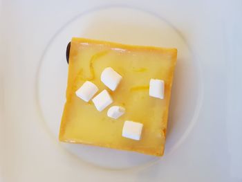 Directly above shot of yellow and spoon on white background