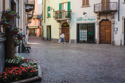 Woman walking on street amidst buildings