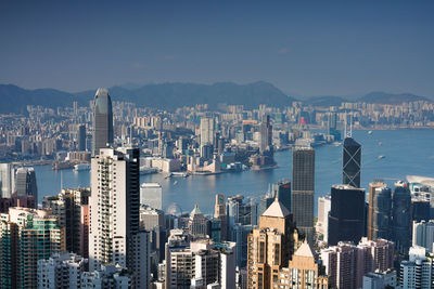 Modern buildings by sea against sky in city