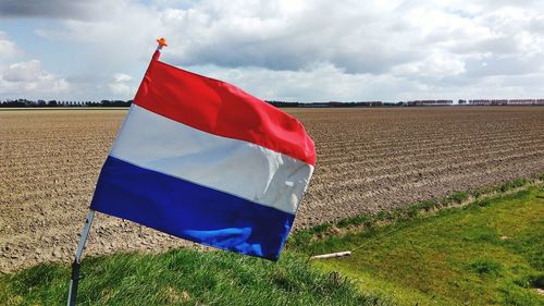 Flag on field against sky