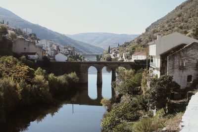 Arch bridge over river against sky