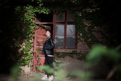 Side view of young woman standing at doorway