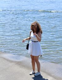 Happy woman wearing white dress standing on promenade