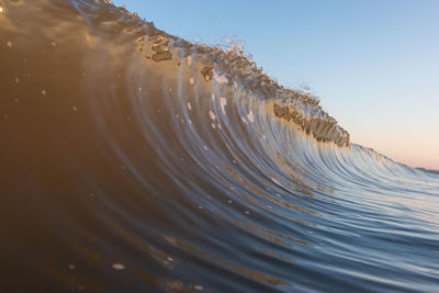 Close-up of water splashing on land against sky