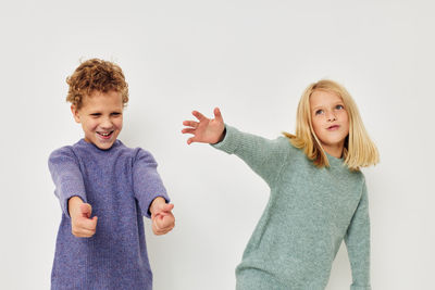 Smiling sibling playing against white background