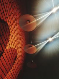 Low angle view of illuminated pendant light hanging on ceiling