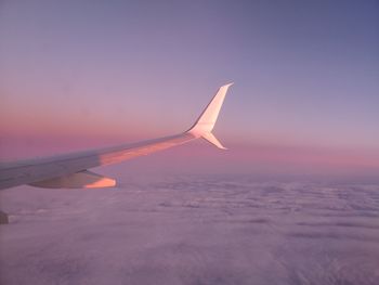 Airplane flying in sky during sunset